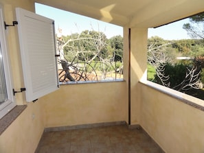 A small balcony with a view of trees and a building in the background. - Apartment Bolko (Medulin)