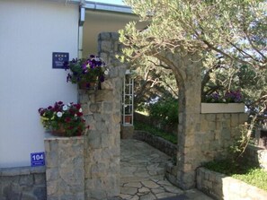 A stone archway leading to a building with a number sign '104' on the wall.