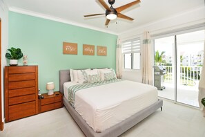 A bedroom with a bed, a nightstand, a dresser, and a ceiling fan. - Playa Turquesa - B-302 -Premier Beachfront Ocean View 400mbps Wifi &Free Netflix (Punta Cana)