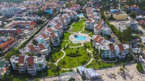A resort with multiple buildings, a central pool, and a beach area with sun loungers. - Playa Turquesa - B-302 -Premier Beachfront Ocean View 400mbps Wifi &Free Netflix (Punta Cana)
