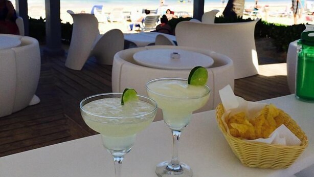 A beachside patio with two margaritas and a basket of chips. - Playa Turquesa - B-302 -Premier Beachfront Ocean View 400mbps Wifi &Free Netflix (Punta Cana)