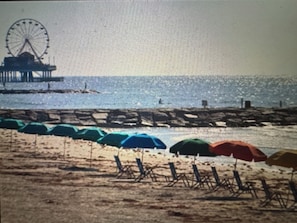 Uma praia com guarda-sóis e um píer.