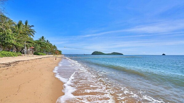 Enjoy a tranquil beach experience with stunning ocean views and access to a nearby island via a scenic bridge.