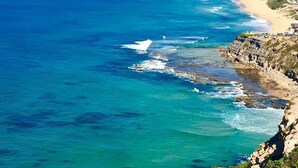 A coastal town with a beach and cliffs. - Walk to the Beach | Live Like A Local | All The Comforts Of Home (Newcastle)