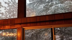 A room with a large window overlooking a snowy landscape with trees. - Surrounded by Pines, Family / Pet Friendly minutes from Snow Valley !!! (Running Springs)
