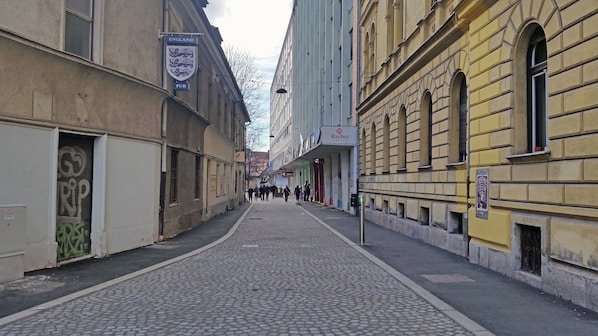 Eine Kopfsteinpflasterstraße, gesäumt von historischen Gebäuden, darunter ein Pub und eine moderne Kunstgalerie.