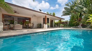 A modern house with a swimming pool, large windows, and a patio area. - LARASATI  @ PALM COVE (PALM COVE)