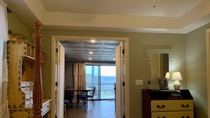 Une chambre d’hôtel comprenant un lit, une commode, un miroir et un coin repas avec une table et des chaises.