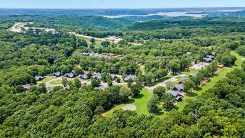 An aerial view of a residential area with multiple houses, roads, and a large body of water in the distance.