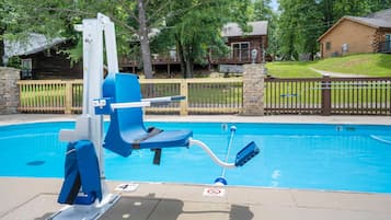 Una piscina con trampolín y puesto de socorrista.