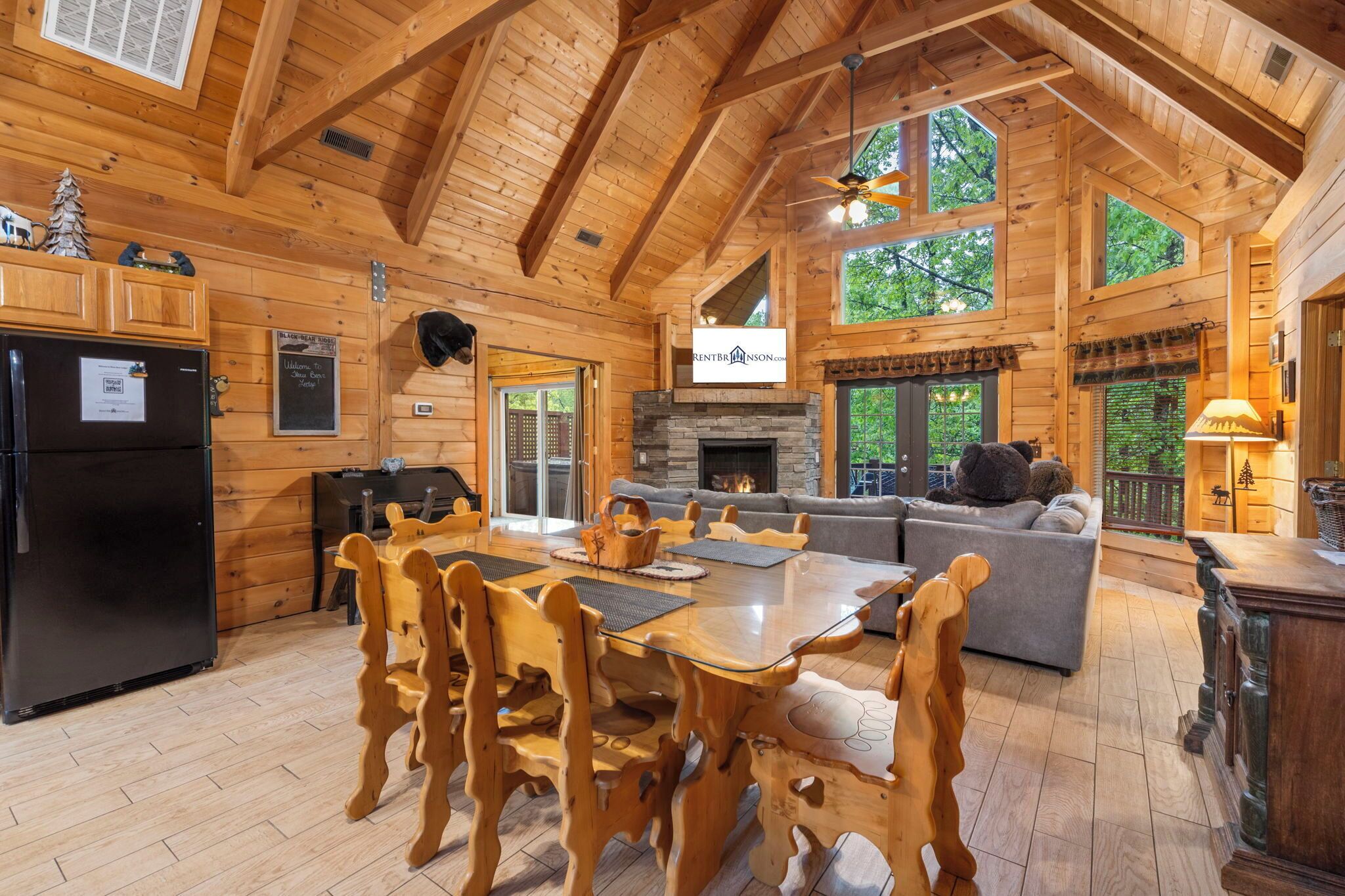 Eine geräumige Holzhütte mit Essbereich, Kamin und gemütlichem Wohnzimmer mit Sofa und Kamin.