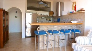 Une cuisine équipée d’un bar, d’un réfrigérateur et d’une table à manger avec des chaises.