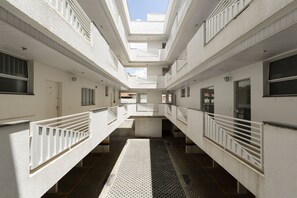 A multi-level interior with a central open space, white walls, and a patterned floor.