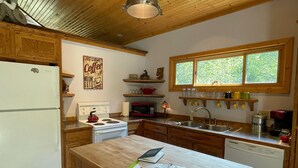 Una cocina con armarios de madera, una isla central y una ventana sobre el lavamanos.