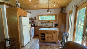 Una cocina amplia con armarios de madera, una isla central y un ventanal grande.