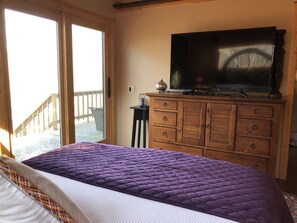 Relax in this serene bedroom with a large bed and flat-screen TV, plus a convenient outdoor deck.