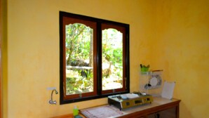 A small kitchen with a window, a sink, a countertop, and a cabinet. - Dajan Buyan Homestay (Bedugul)