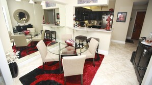 Una cocina moderna con armarios oscuros, una encimera blanca y una alfombra roja y negra.
