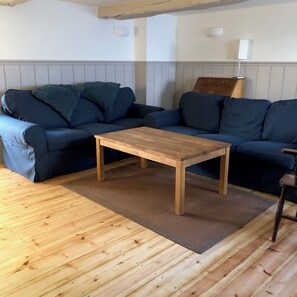 A room with a wooden floor, a blue sofa, a wooden coffee table, and a lamp. - COMFORTABLE, TRANQUIL, HOUSE ON RIVER TEIFI  LARGE GARDEN, CENTRAL, FREE PARKING (Cardigan)