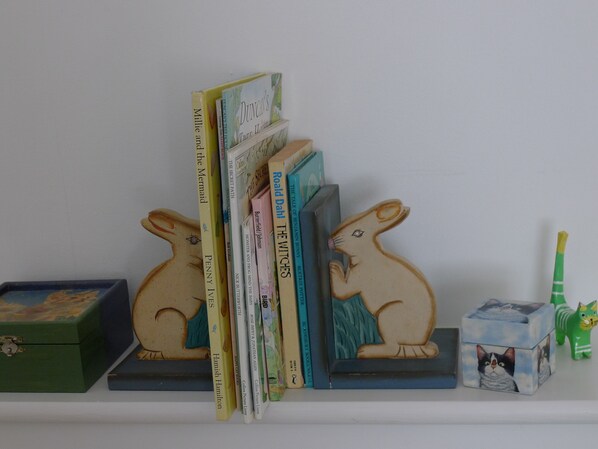A bookshelf with books and two wooden animal-shaped bookends. - COMFORTABLE, TRANQUIL, HOUSE ON RIVER TEIFI LARGE GARDEN, CENTRAL, FREE PARKING (Cardigan)