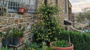 A stone building with a balcony, potted plants, and a view of the countryside. - Farmhouse with infinity pool: A unique experience-Onice (castellabate)