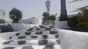 A set of white stone steps leading up to a white building with a statue at the top.