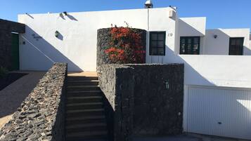 A white building with a stone staircase leading to a door marked "19".