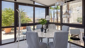 Un comedor moderno con una mesa redonda, sillas grises y una planta en maceta.