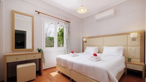 Habitación de hotel con cama, mesita de noche y escritorio con silla.