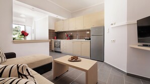 Una cocina moderna con comedor, sofá y televisor.