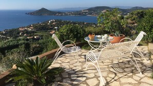 An outdoor patio with a table and chairs overlooking a coastal landscape. - AGAY - Charming villa with heated swimming pool and exceptional sea view (Saint-Raphaël)