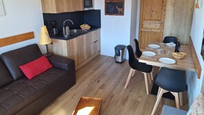 A compact living space with a kitchenette, dining area, and a sofa. - apartment/ flat - Alpe d'huez (Huez)