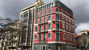 Un edificio de varios pisos con fachada roja y balcones.