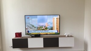 Un televisor montado en una pared, mostrando un noticiero.
