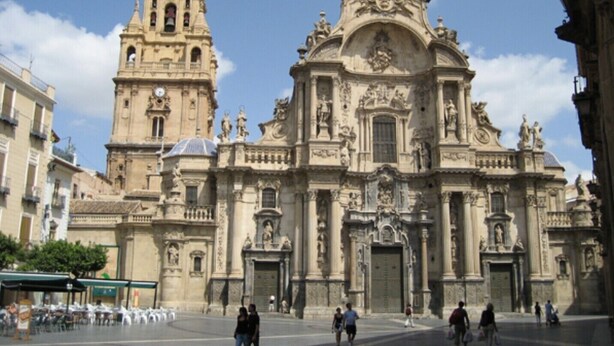 A historic building with a prominent bell tower and ornate facade, featuring statues and intricate architectural details. - Comfortable apartment for 2 people (Murcia)