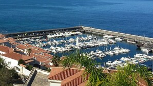 A marina with numerous boats docked, surrounded by buildings with red-tiled roofs. - APARTMENT WITH SEA VIEWS AND FANTASTIC SUNSHINE (Santiago del Teide)