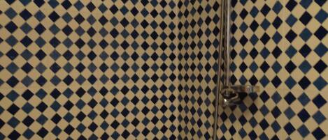 Une salle de bain dont le sol est recouvert de carreaux disposés en motif à carreaux.