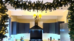 A modern kitchen with dark blue cabinets, a black stove, and a stainless steel refrigerator.