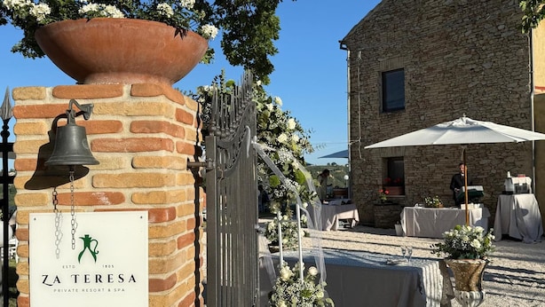 A private resort with a stone building, a bell, and a sign for Zá Teresa.