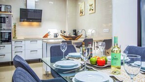 A modern kitchen with a dining area set for a meal. - Villa Qura - Three Bedroom Villa, Sleeps 6 (Montaña Roja)