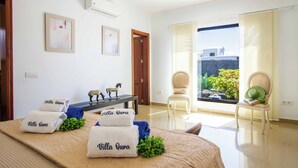 A hotel room with a bed, a desk, a chair, and a view of the outside. - Villa Qura - Three Bedroom Villa, Sleeps 6 (Montaña Roja)