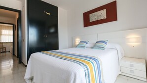 A bedroom with a bed, bedside tables, a wardrobe, and a wall-mounted artwork.