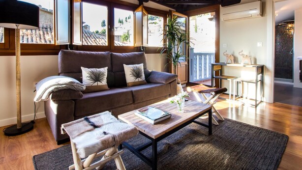 A cozy living room with a sofa, a coffee table, and a cat tree. - Fantastic penthouse with terrace and views (Granada)