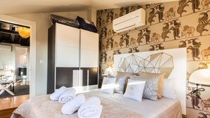 A bedroom with a bed, pillows, and a headboard. There is a wall with a patterned design and an air conditioning unit above the bed. - Fantastic penthouse with terrace and views (Granada)