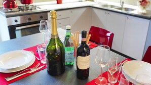 A dining table set with wine bottles, glasses, and plates in a modern kitchen. - Bellaria Park "Hills View" Residences (san lazzaro di savena (Bologna))