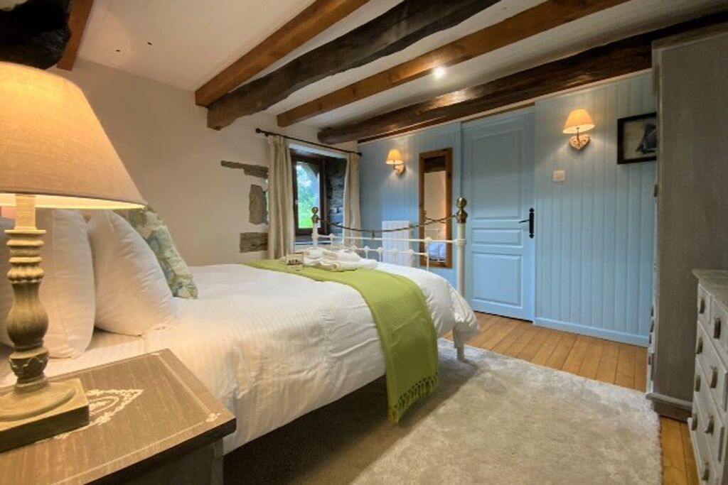 Une chambre à coucher avec un lit, une lampe de chevet et une vue sur un balcon.