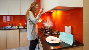 Et moderne køkken med gasblus, vask og en velkomstskilt på bordet.