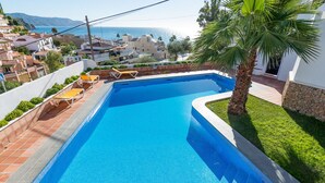 A rectangular swimming pool with a clear blue water, surrounded by a tiled deck and a small grassy area. - 2 Bedrooms | Alamar 1, nº3 | CG R1306 (Nerja)