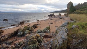A rocky beach with a view of the sea and distant hills. - Uninterrupted sea views across the Moray Firth home to dolphins (Rosemarkie)