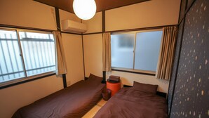 A hotel room with two beds, a window, and a ceiling fan. - JQ Villa Kyoto Higashikujo (Kyoto)